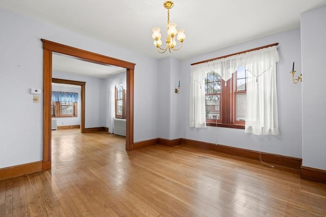 unfurnished dining area with radiator, a wealth of natural light, and a chandelier
