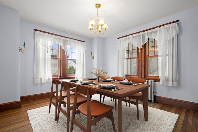 dining room with hardwood / wood-style flooring, radiator, baseboards, and a notable chandelier