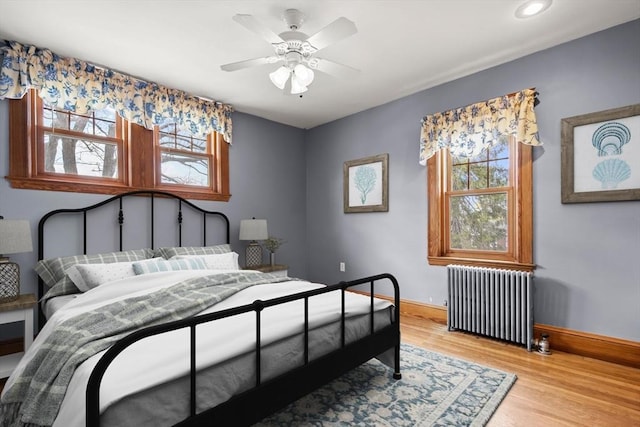 bedroom with recessed lighting, radiator heating unit, light wood finished floors, a ceiling fan, and baseboards