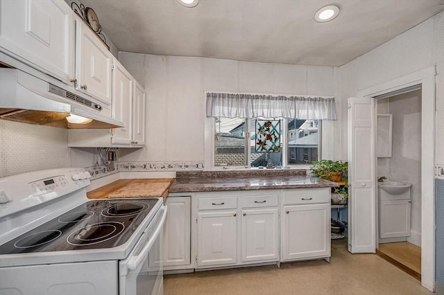 kitchen with tasteful backsplash, white electric range oven, and white cabinets