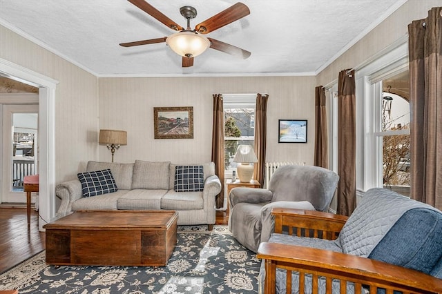 living room with hardwood / wood-style floors, crown molding, and ceiling fan