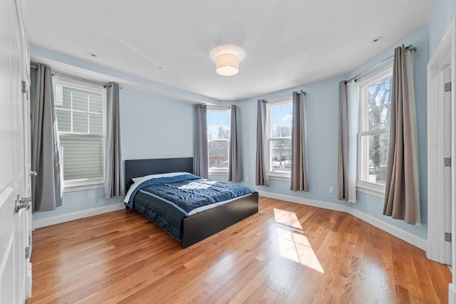 bedroom featuring multiple windows and light hardwood / wood-style floors