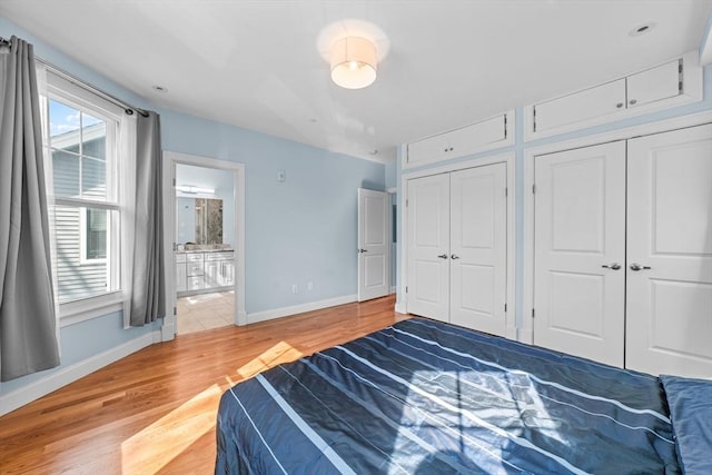 bedroom featuring ensuite bathroom and light wood-type flooring