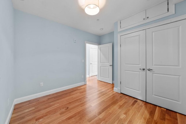 unfurnished bedroom with light hardwood / wood-style flooring and a closet