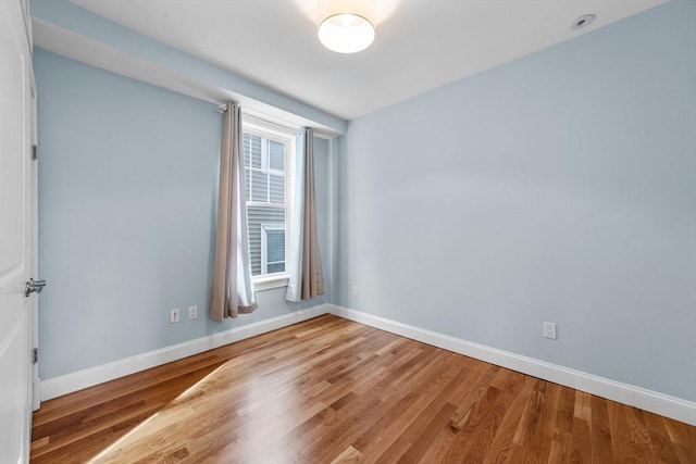 empty room with hardwood / wood-style flooring and a wealth of natural light