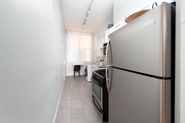 1411 Washington St Unit 7, Boston, MA 02118 - kitchen featuring stainless steel appliances, track lighting, baseboards, washer / dryer, and light tile patterned flooring
