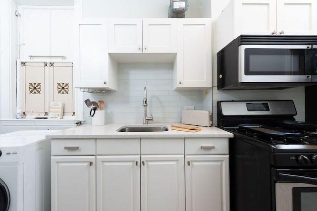 1411 Washington St Unit 7, Boston, MA 02118 - kitchen with gas range, stainless steel microwave, a sink, washer / dryer, and white cabinets
