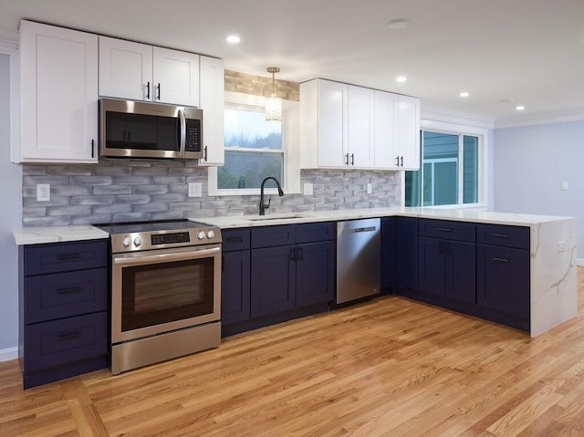 kitchen with stainless steel appliances, white cabinetry, sink, and kitchen peninsula