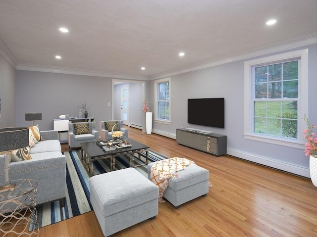 living room with ornamental molding, a baseboard heating unit, and light wood-type flooring