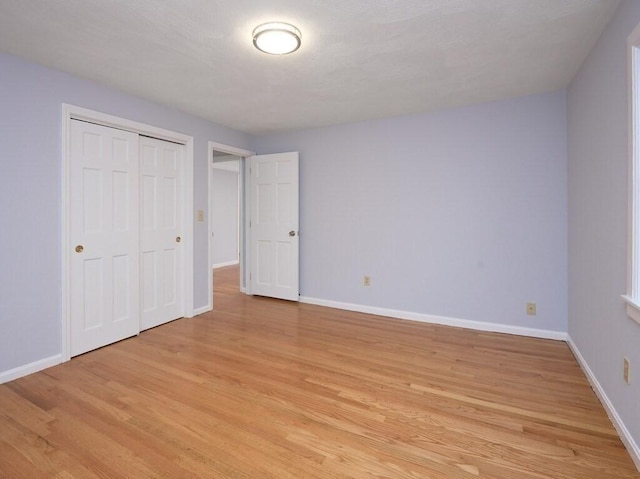 unfurnished bedroom with a closet and light hardwood / wood-style flooring