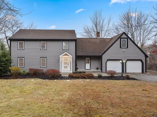 front facade with a garage and a front lawn