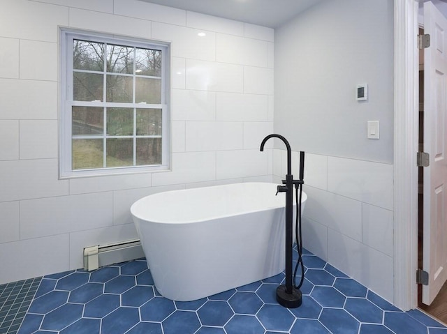 bathroom with baseboard heating, a bathing tub, tile patterned flooring, and tile walls