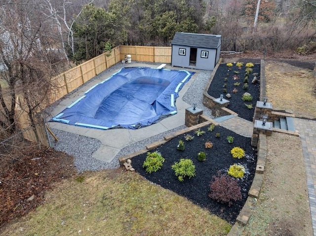 view of pool with a diving board and a shed