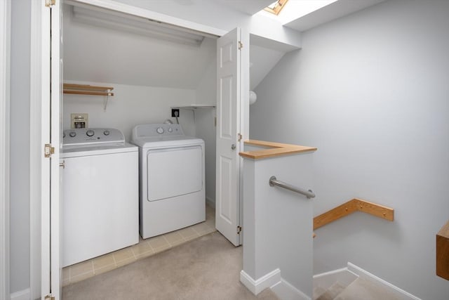 clothes washing area featuring a skylight, separate washer and dryer, and light carpet