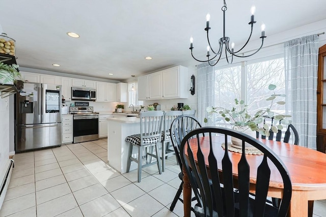 kitchen featuring sink, stainless steel appliances, white cabinetry, and light tile patterned floors