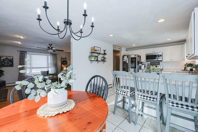 tiled dining room with sink, a baseboard radiator, and ceiling fan with notable chandelier