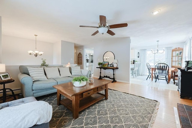 living room with ceiling fan with notable chandelier, hardwood / wood-style floors, and baseboard heating