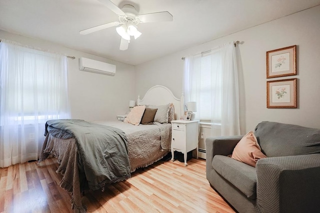 bedroom with ceiling fan, a baseboard heating unit, light hardwood / wood-style floors, and a wall unit AC