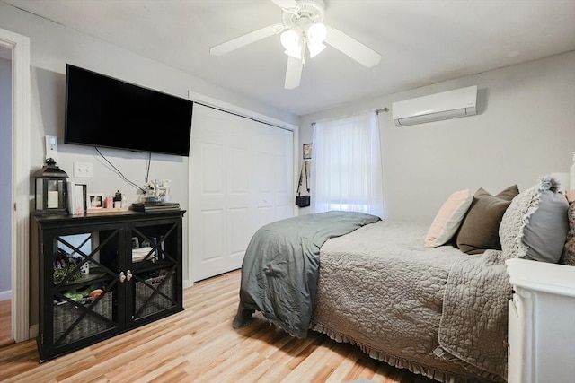 bedroom with ceiling fan, hardwood / wood-style flooring, a closet, and a wall mounted AC