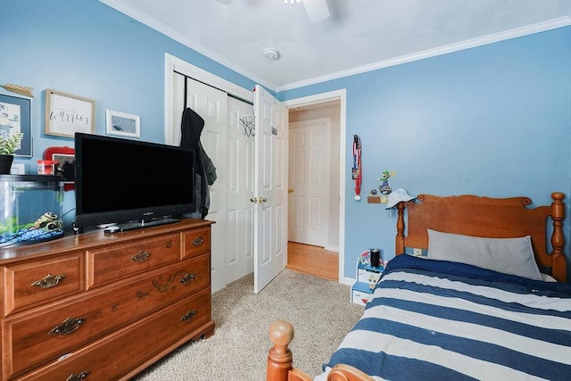 carpeted bedroom with a closet, ceiling fan, and ornamental molding