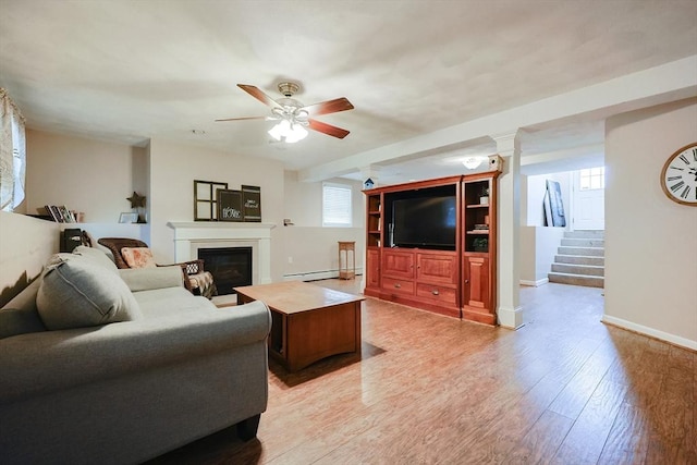 living room with ceiling fan, baseboard heating, and light wood-type flooring