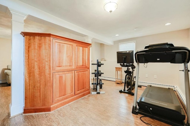 workout room with ornate columns, light hardwood / wood-style flooring, and a baseboard heating unit