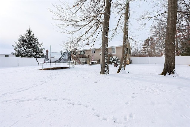 yard covered in snow featuring a trampoline