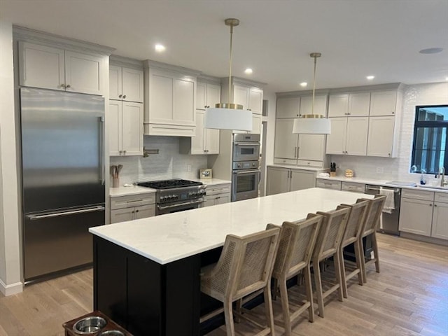 52 Round Farm Rd, Rehoboth, MA 02769 - kitchen with high quality appliances, backsplash, light wood-style flooring, a kitchen bar, and recessed lighting