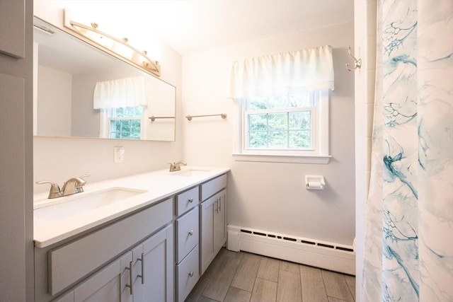 54 Mountain View Rd, Leominster, MA 01453 - full bathroom with baseboard heating, healthy amount of natural light, double vanity, and wood finished floors