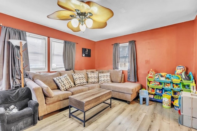 living room with light hardwood / wood-style floors and ceiling fan