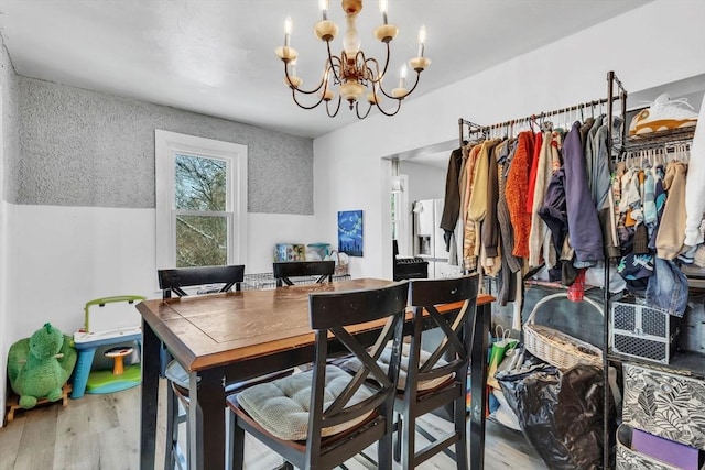 dining space featuring hardwood / wood-style flooring and an inviting chandelier