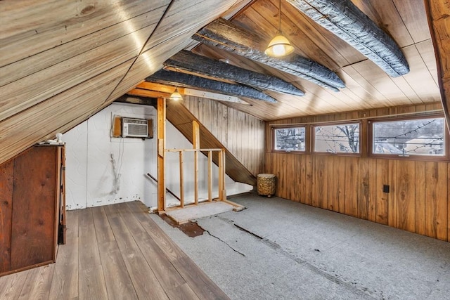 additional living space featuring lofted ceiling, a wall mounted AC, and wood walls