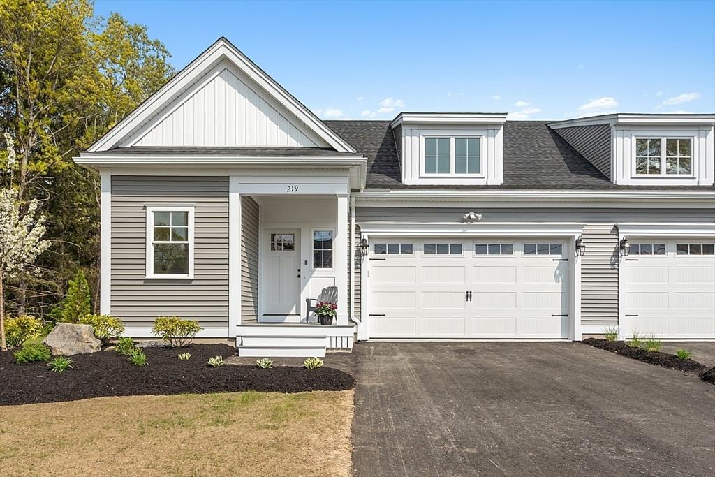 view of front of house with driveway, an attached garage, and roof with shingles