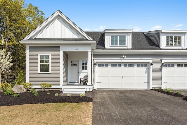 view of front of house with driveway, an attached garage, and roof with shingles