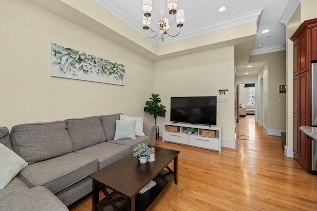 living room with light wood finished floors, baseboards, ornamental molding, recessed lighting, and an inviting chandelier