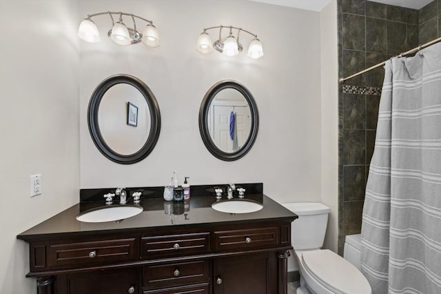 bathroom with double vanity, toilet, and a sink