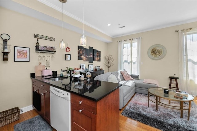 kitchen with a wealth of natural light, a sink, dark countertops, a peninsula, and white dishwasher