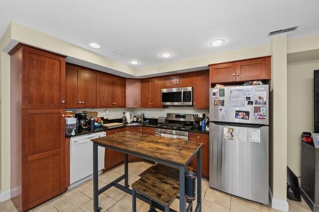 kitchen with light tile patterned floors, visible vents, recessed lighting, stainless steel appliances, and dark countertops