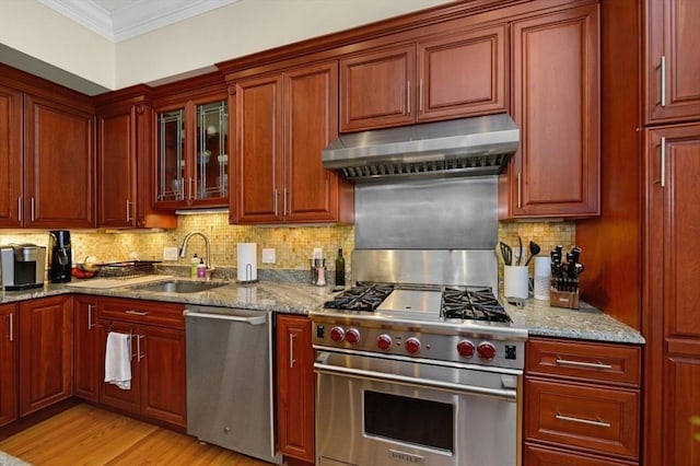 kitchen featuring under cabinet range hood, a sink, tasteful backsplash, stainless steel appliances, and crown molding