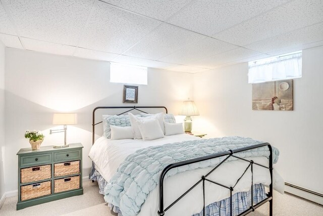 bedroom featuring carpet floors, baseboards, a baseboard heating unit, and a drop ceiling