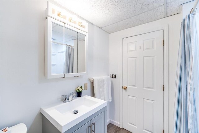 full bathroom featuring vanity, a shower with shower curtain, wood finished floors, and toilet