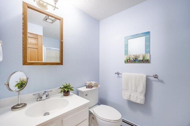 bathroom with vanity, a baseboard heating unit, and toilet