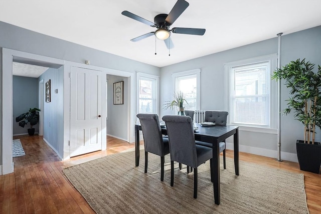 dining area featuring wood-type flooring and ceiling fan