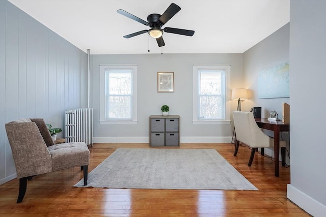 home office featuring ceiling fan, wood-type flooring, and radiator