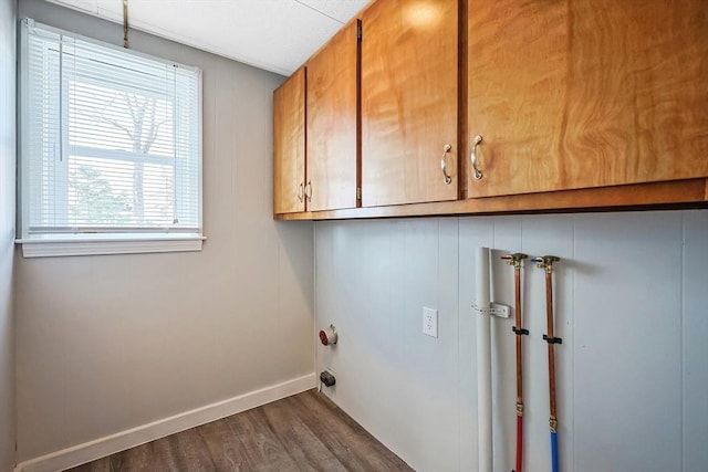 clothes washing area featuring cabinets, washer hookup, and dark hardwood / wood-style floors