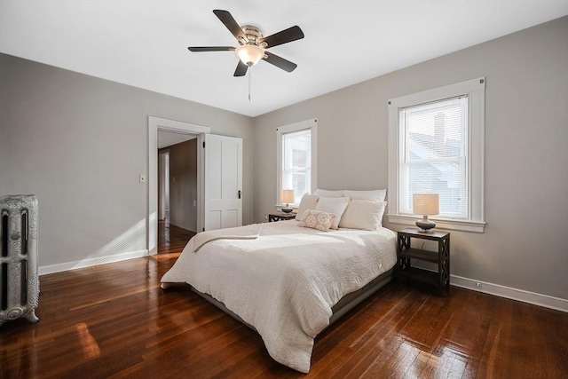 bedroom featuring multiple windows, dark wood-type flooring, and ceiling fan