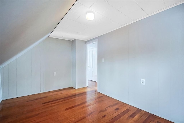 unfurnished room featuring lofted ceiling and hardwood / wood-style floors