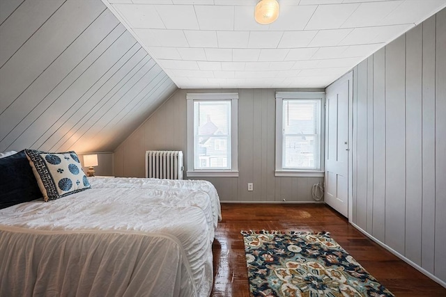 bedroom with lofted ceiling, radiator, and dark wood-type flooring