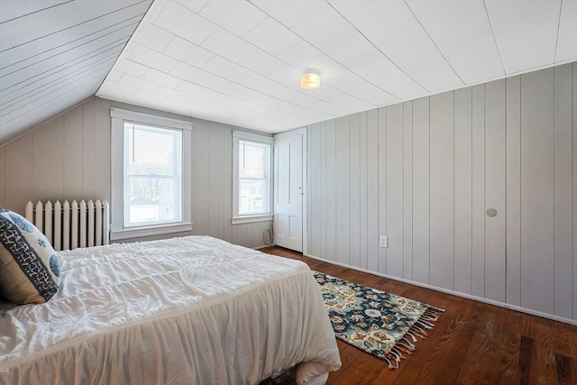 bedroom featuring radiator, dark wood-type flooring, and vaulted ceiling