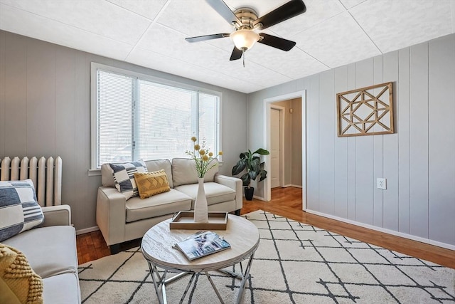 living room with ceiling fan, radiator, and hardwood / wood-style floors